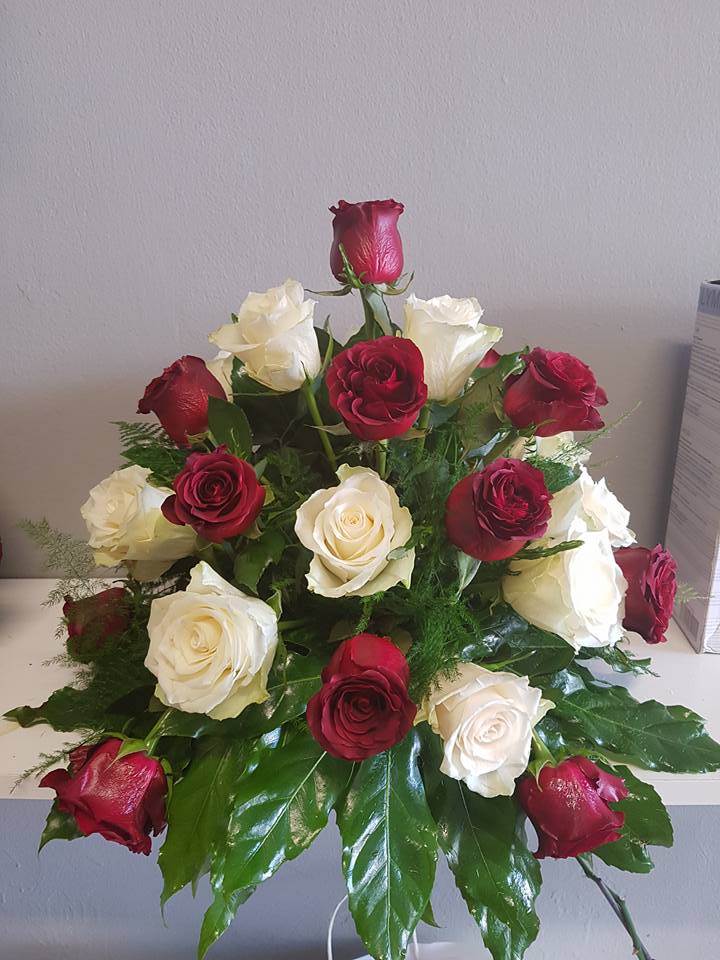 composizione con rose bianche e rosse e foglie verdi