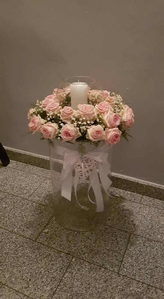 decorazione floreale con rose rosa e candela