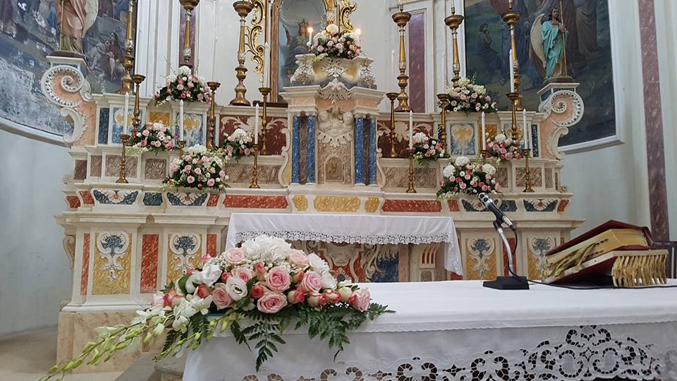 altare di una chiesa con addobbi floreali per matrimonio