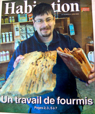 Un homme tient un morceau de bois sur la couverture d'un magazine