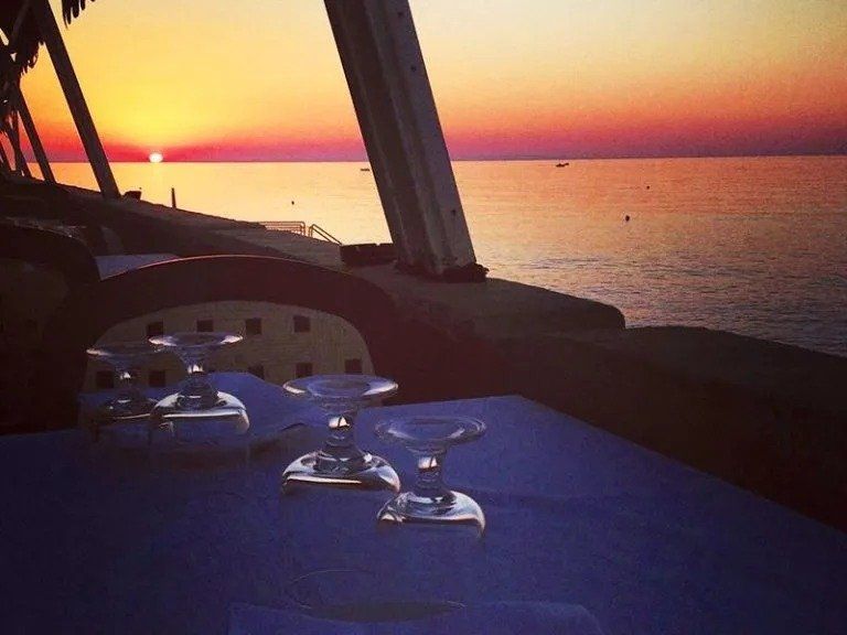 tavolo apparecchiato sul mare al tramonto