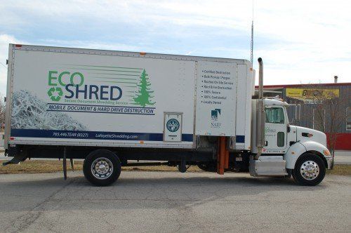 A white eco shred truck is parked on the side of the road