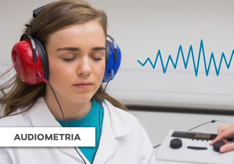 CONSULPRIME.COM  - Uma mulher usando fones de ouvido durante um teste de audiometria, com um gráfico de onda sonora azul.