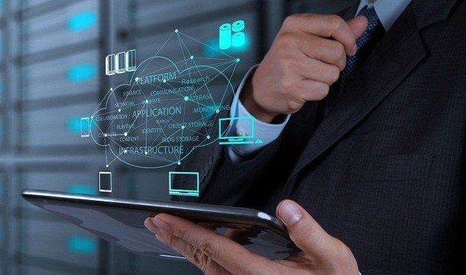 CONSULPRIME.COM - Homem de terno segurando um tablet, nuvem digital com ícones de tecnologia flutuando acima e sala de servidores ao fundo.