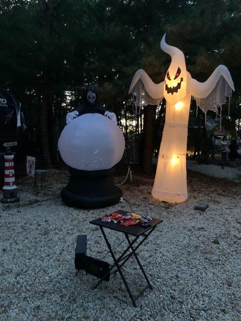A large inflatable ghost is standing next to a table