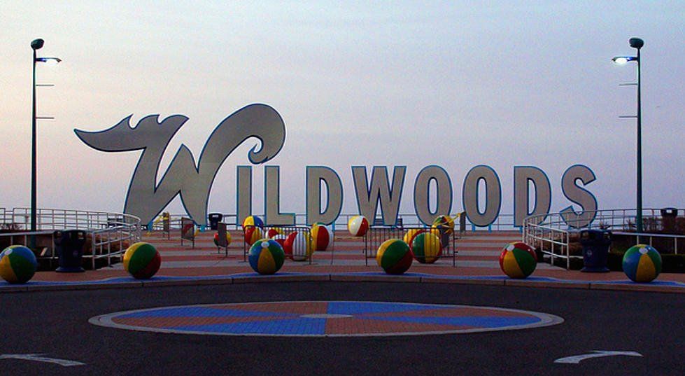 A sign for wildwoods is surrounded by beach balls