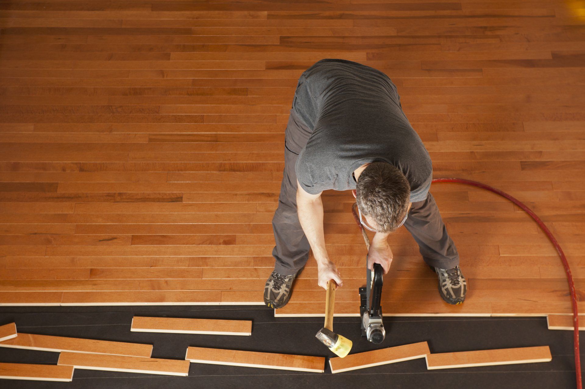 Engineered Hardwood Flooring — Man Working on Wood Flooring in Bellmawr, NJ Engineered Hardwood Flooring — Man Working on Wood Flooring in Bellmawr, NJ