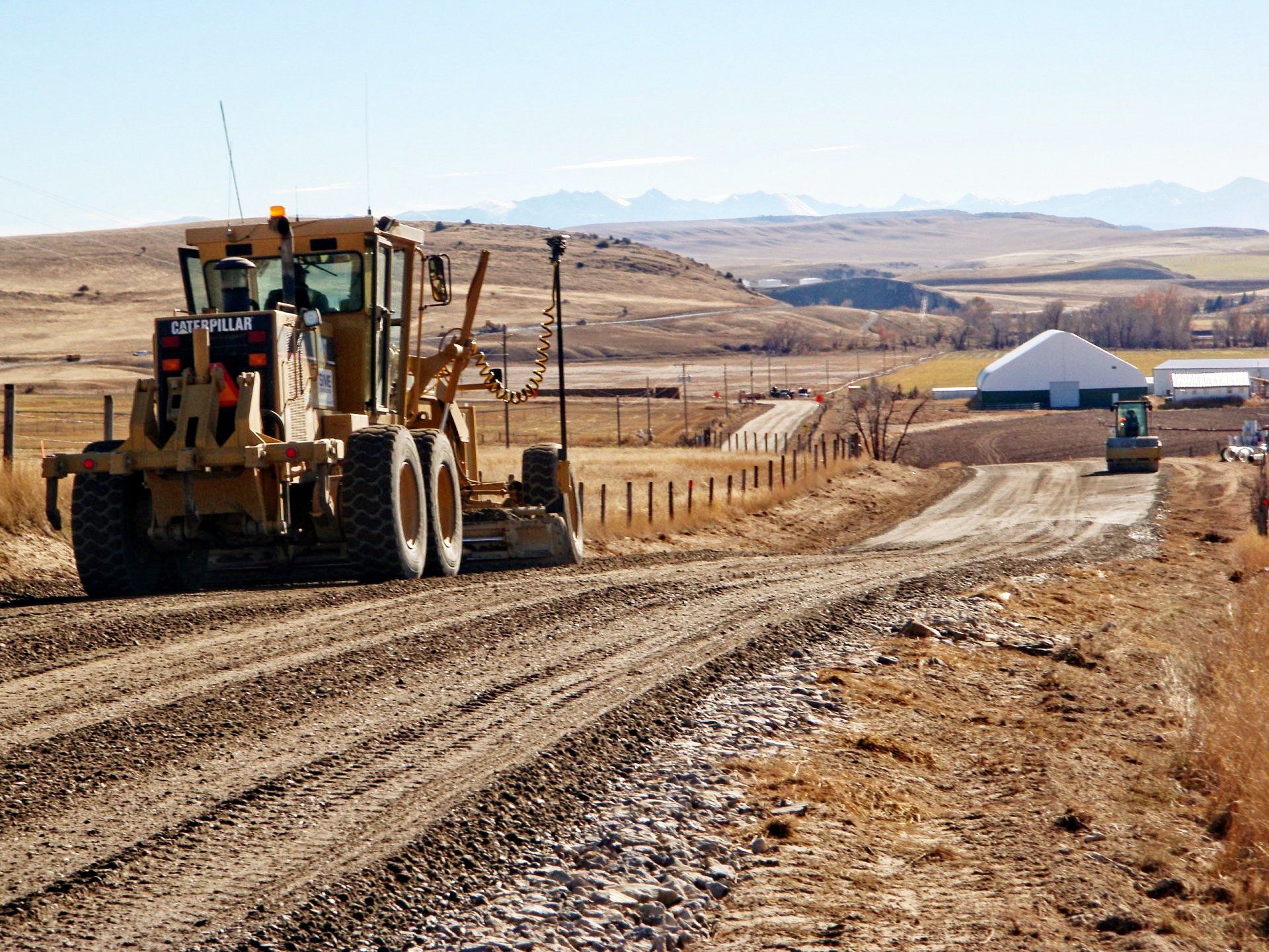 A bulldozer is driving down a dirt road.