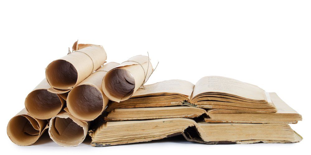 Stack of old scrolls and books on a white background.