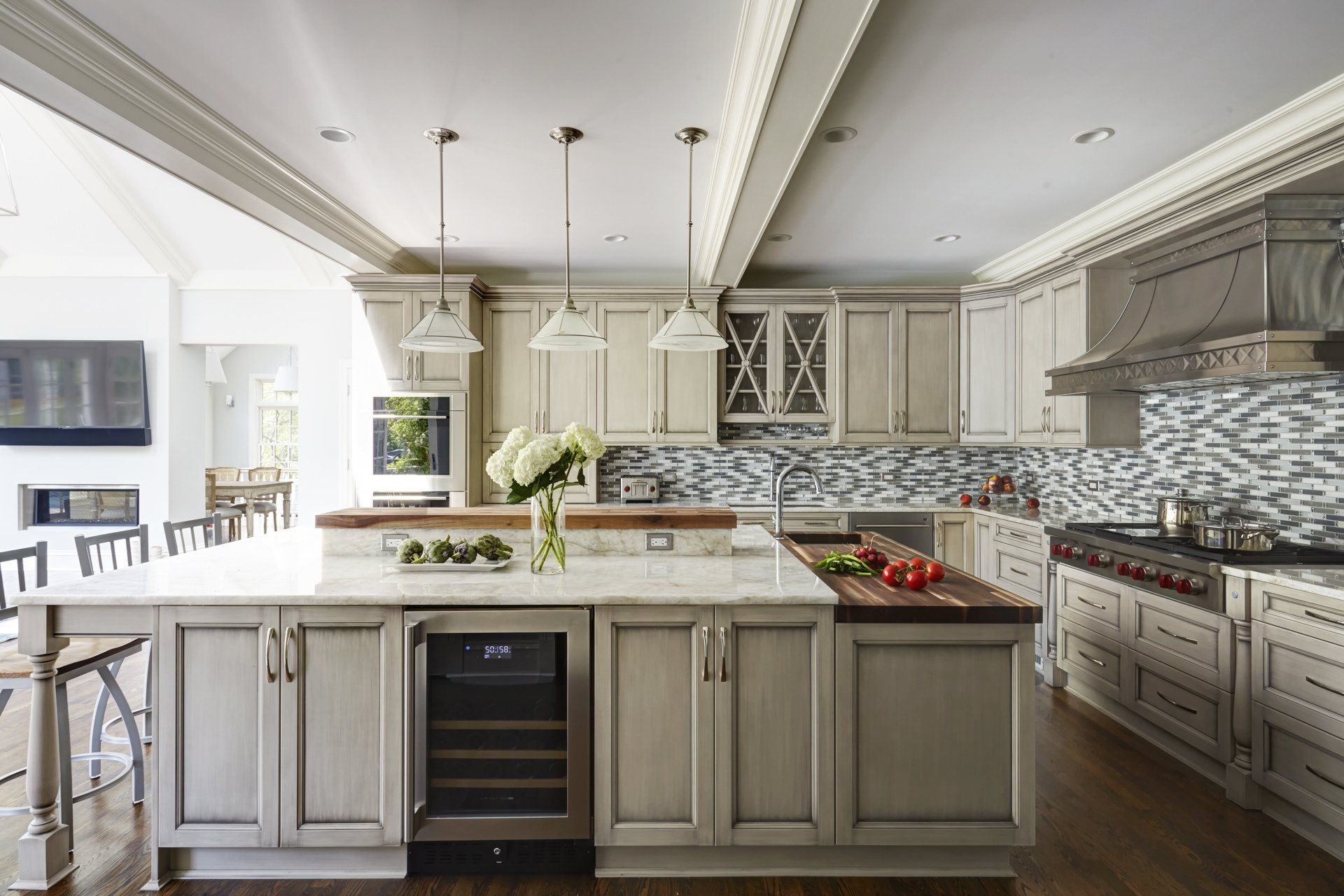 A kitchen with white cabinets and a large island in the middle