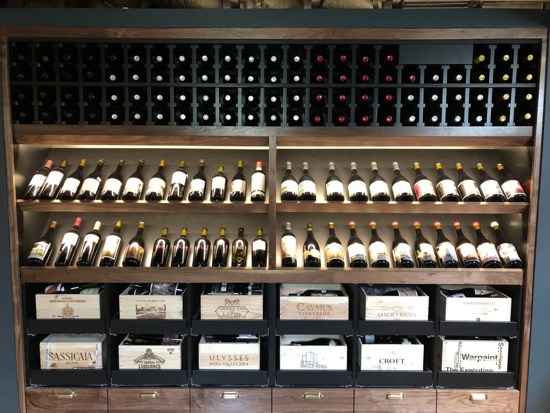 A wine rack filled with lots of wine bottles and boxes.