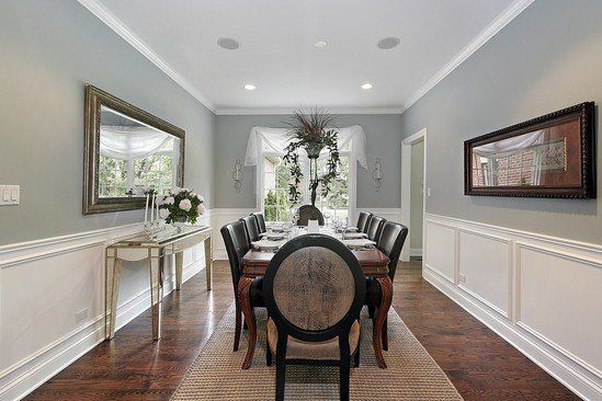 A long dining room with a long table and chairs.