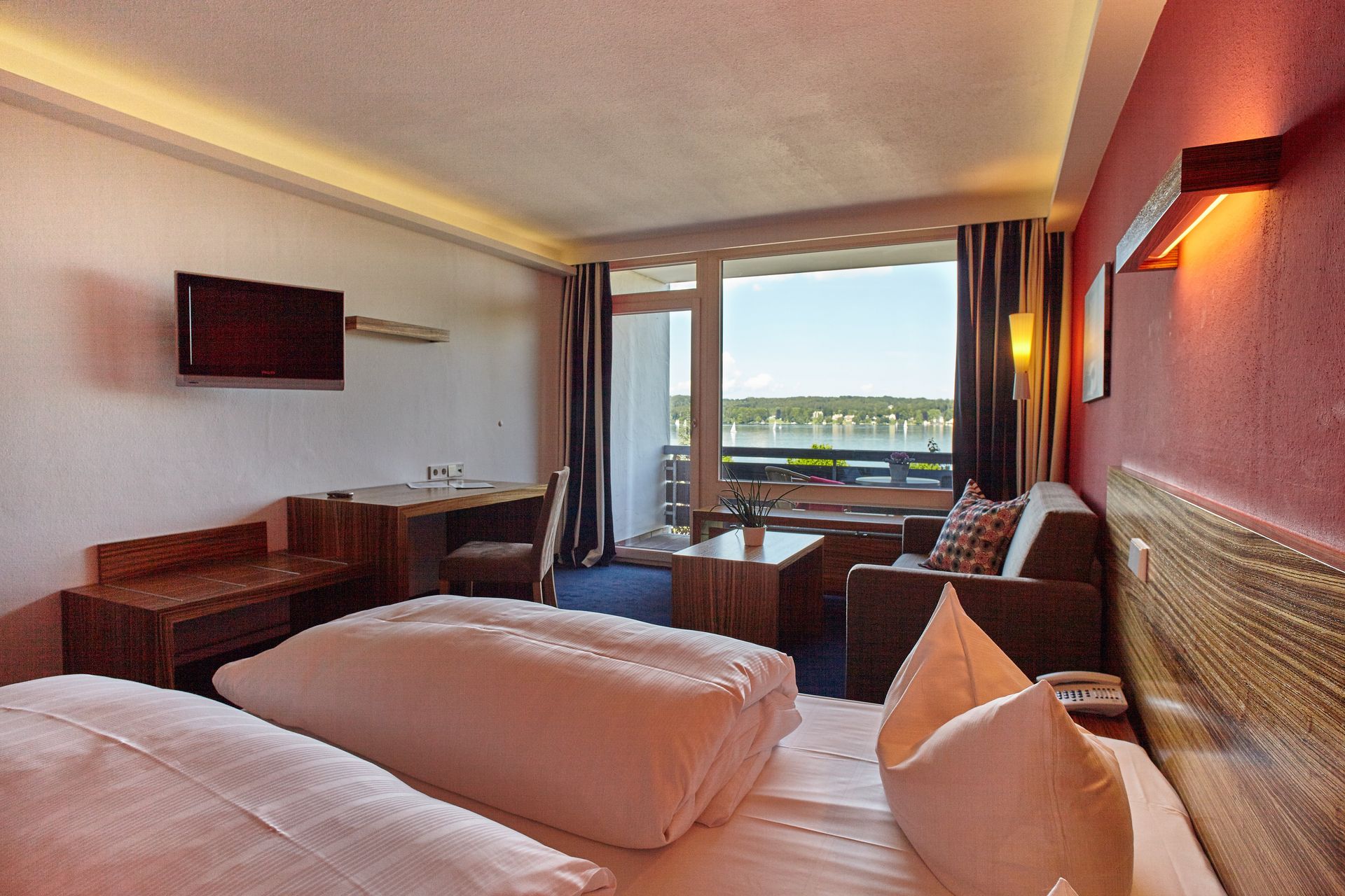 Großzügiges Hotelzimmer mit Seeblick mit Doppelbett und moderner Einrichtung.