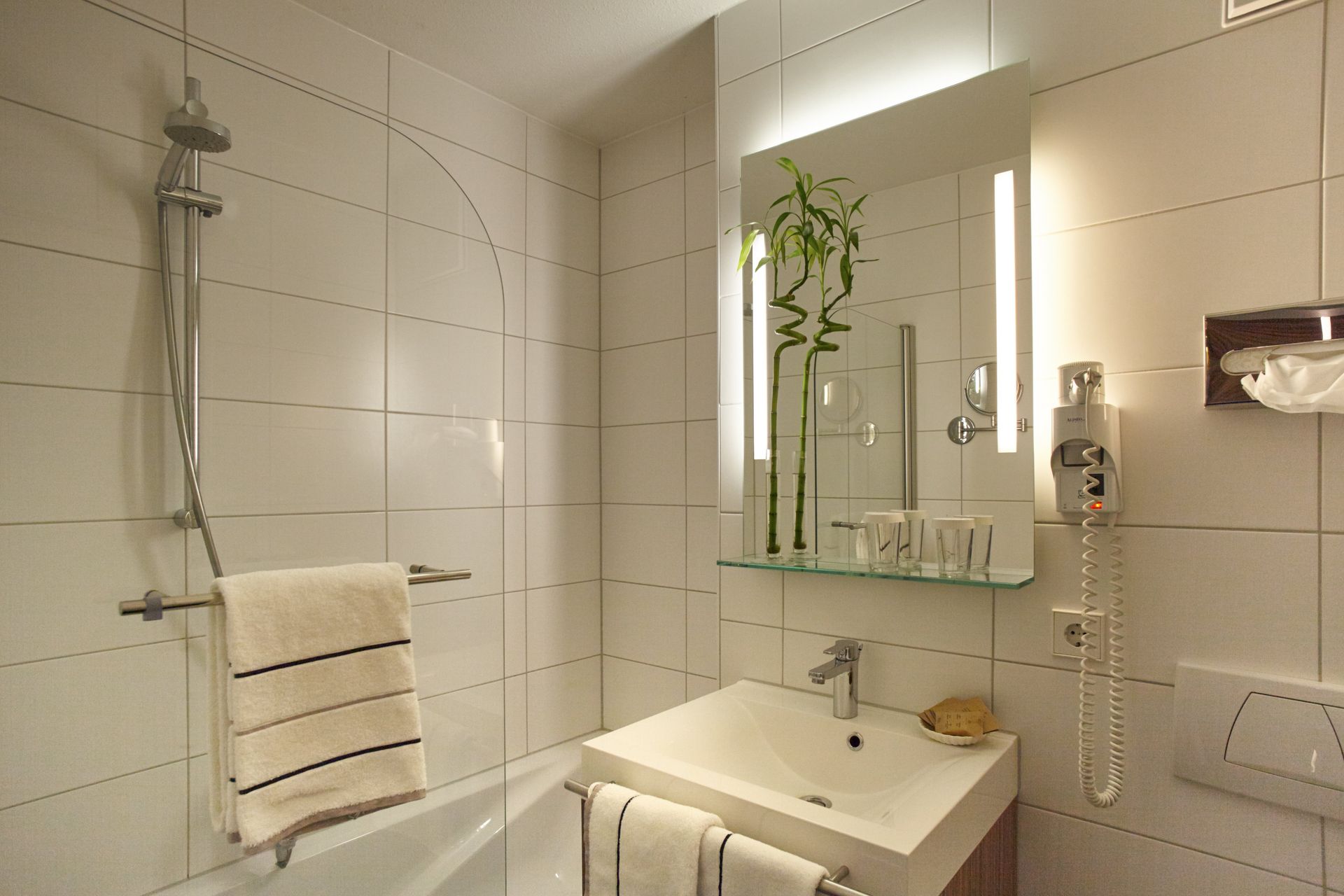 Ein Badezimmer mit Waschbecken, Badewanne und Spiegel