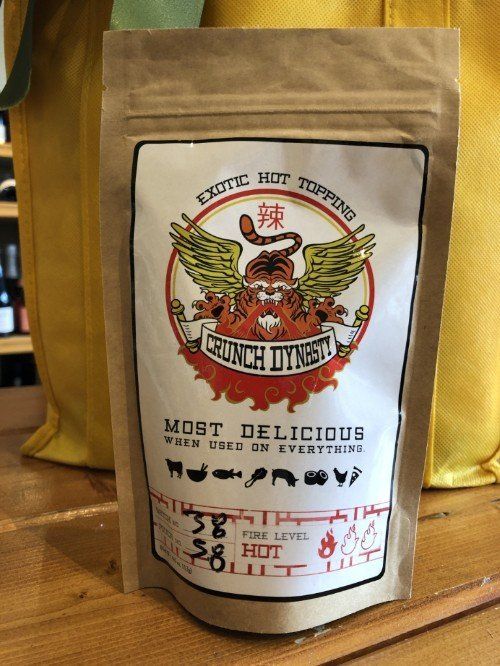 a bag of crunch dungeon hot sauce is sitting on a wooden table