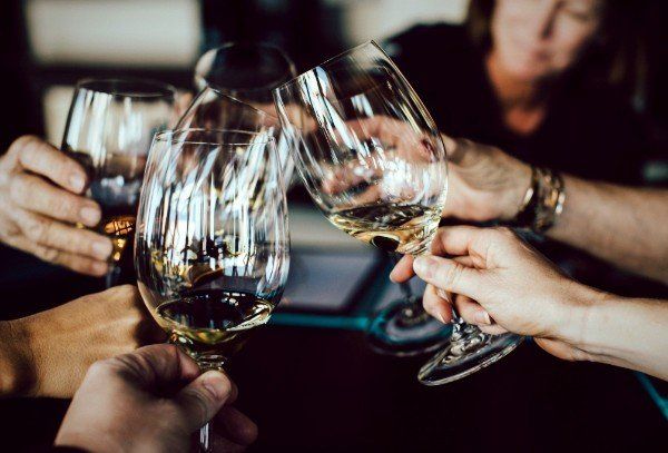 a group of people are toasting with wine glasses .