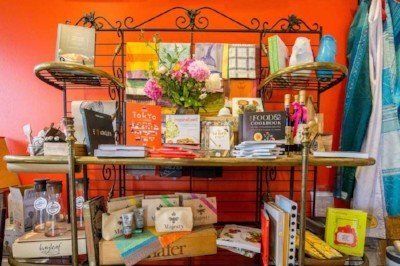 a shelf filled with books and a vase of flowers .