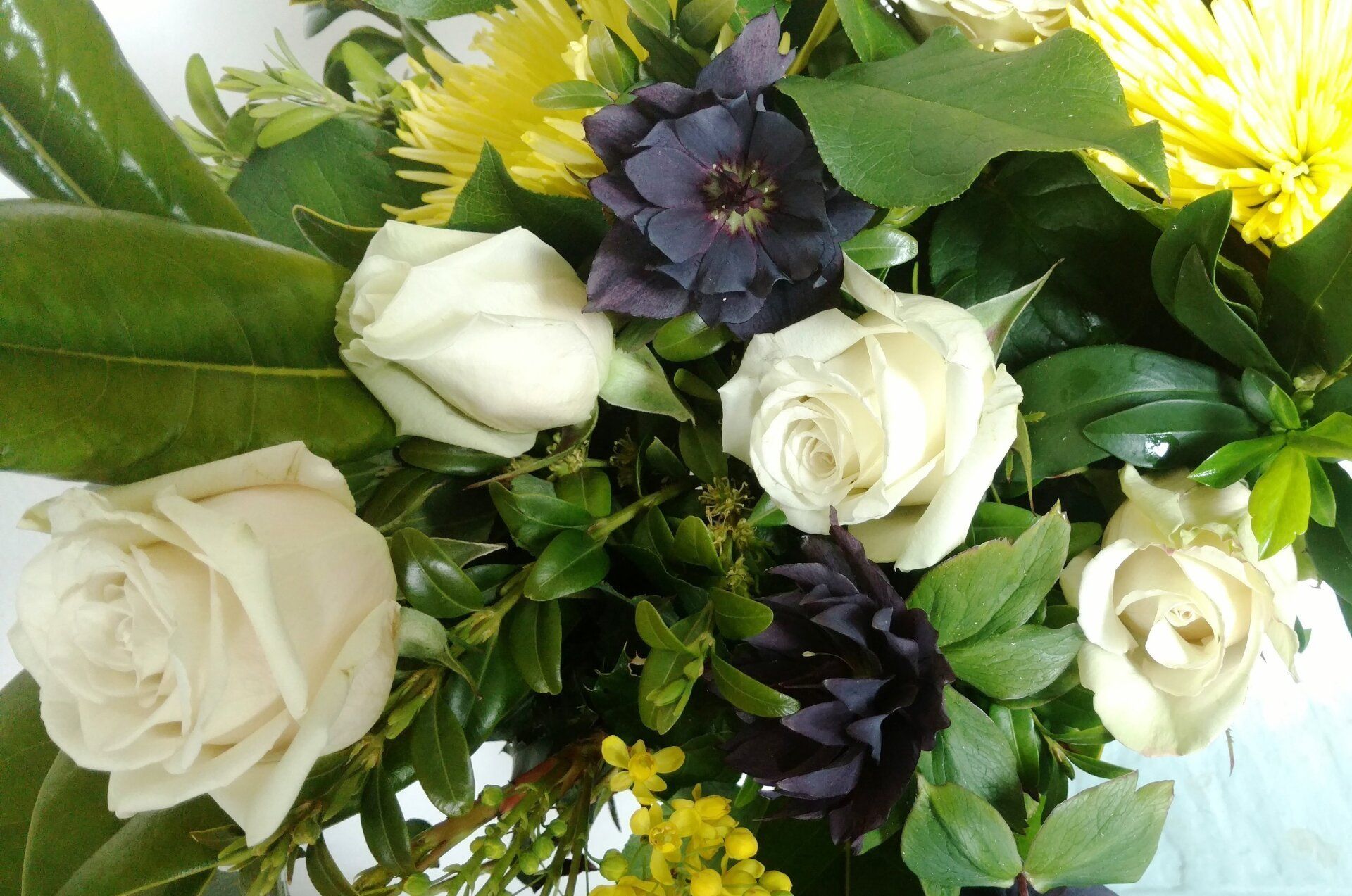 a close up of a bouquet of white roses and yellow flowers