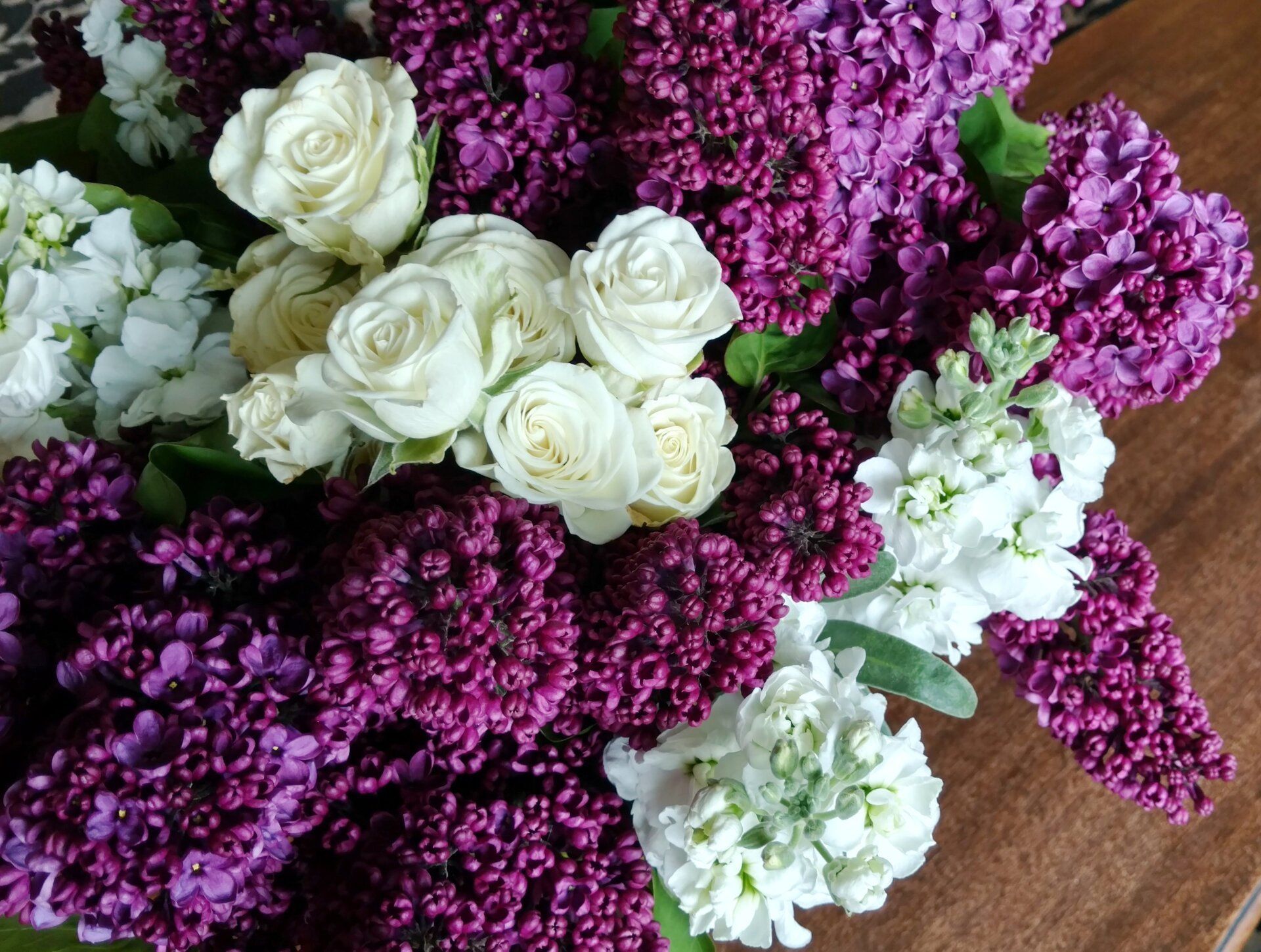a bouquet of purple and white flowers on a wooden table