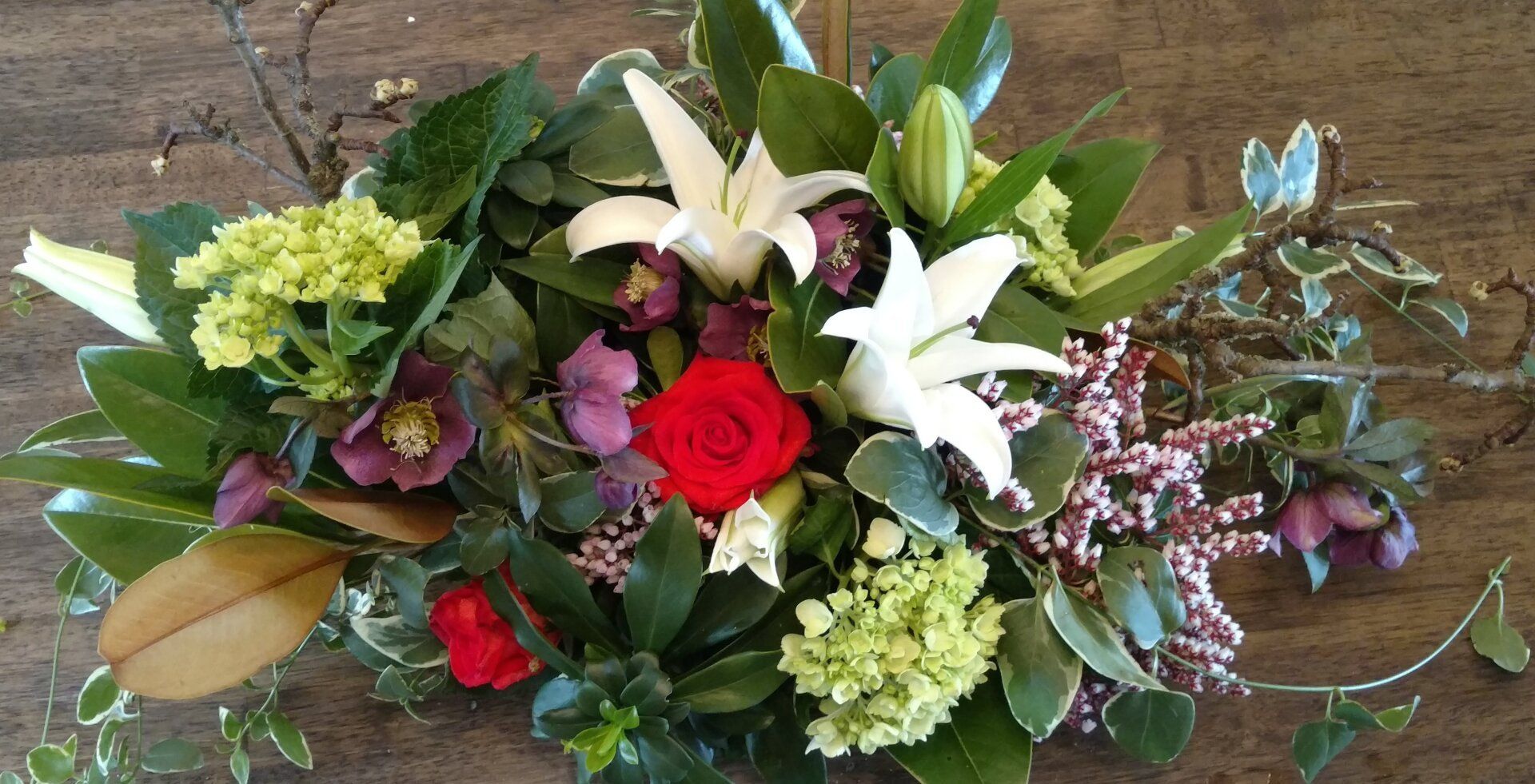 a bouquet of flowers is sitting on a wooden table .