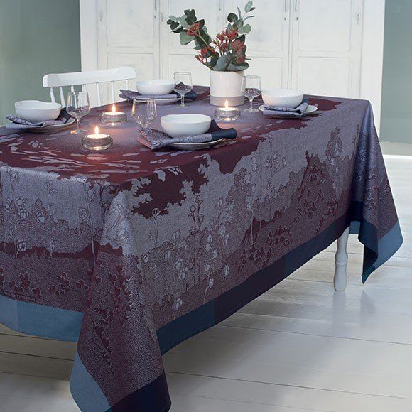 a table with plates bowls and candles on it