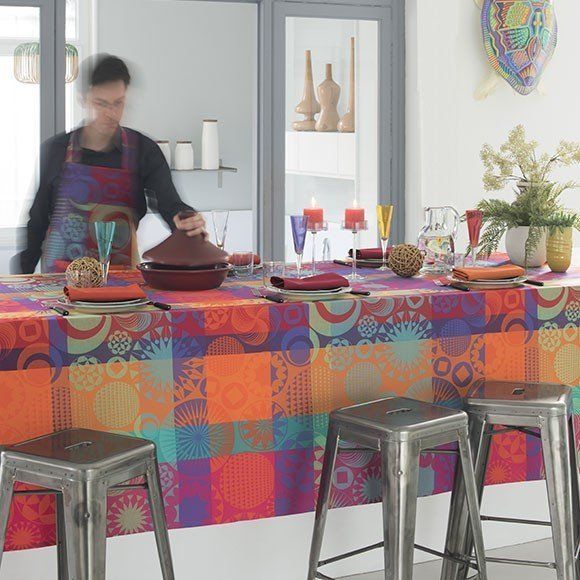 a table with a colorful table cloth and stools