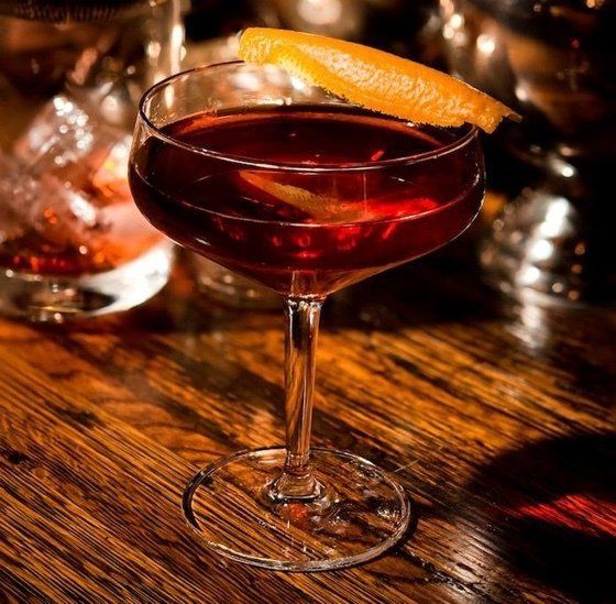 a wine glass with a slice of orange in it