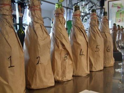 a row of wine bottles wrapped in brown paper with numbers 1 through 6 on them