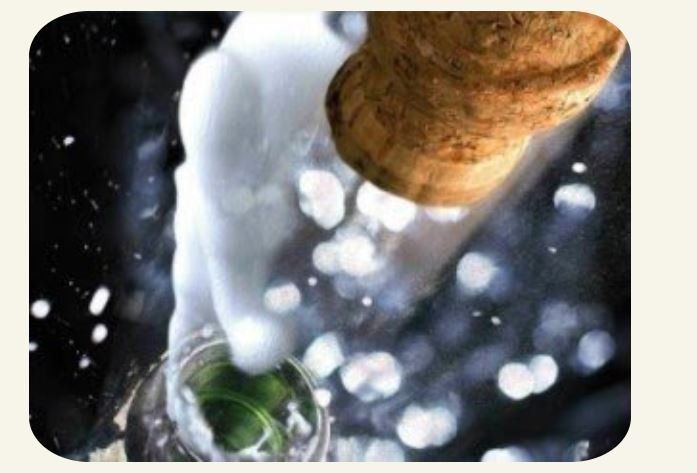 a close up of a person pouring champagne into a glass