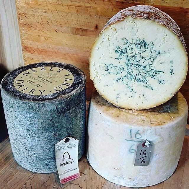 two pieces of cheese are stacked on top of each other on a wooden table