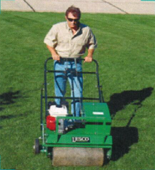 Hand removing grass — Residential Lawn Services in Salina, KS