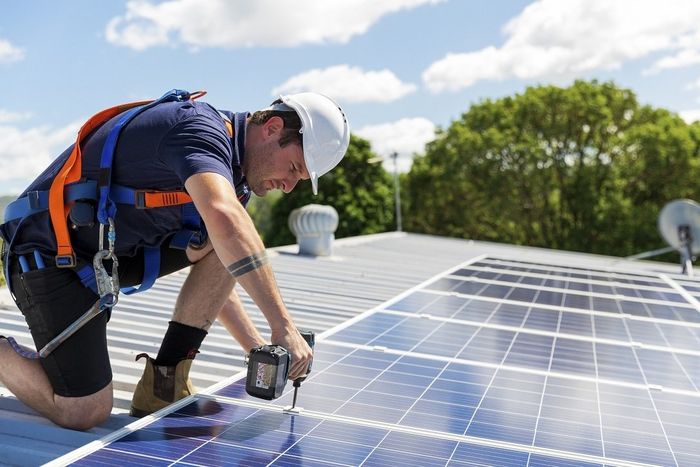 Roofing contractor installing colorbond roof and solar panel for a commercial building in Hobart, TAS.