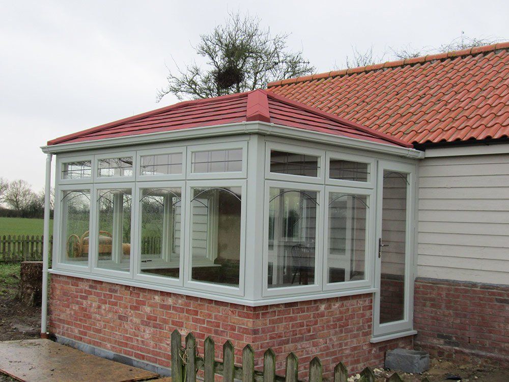 Double-hipped Edwardian conservatory with Evolution windows in grained French grey (external) and white (internal), dwarf wall, Guardian Warm Roof and Microlite tiles – Thorndon, Eye, Suffolk