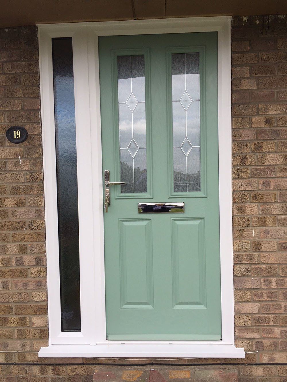 Composite door and side screen of UPVC Victorian conservatory with Guardian Warm Roof and slate effect tiles