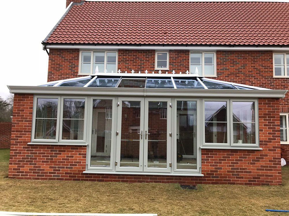 UPVC double-hipped Edwardian orangery with glass roof and wood grained effect Agate Grey frame – Snape, Saxmundham, Suffolk