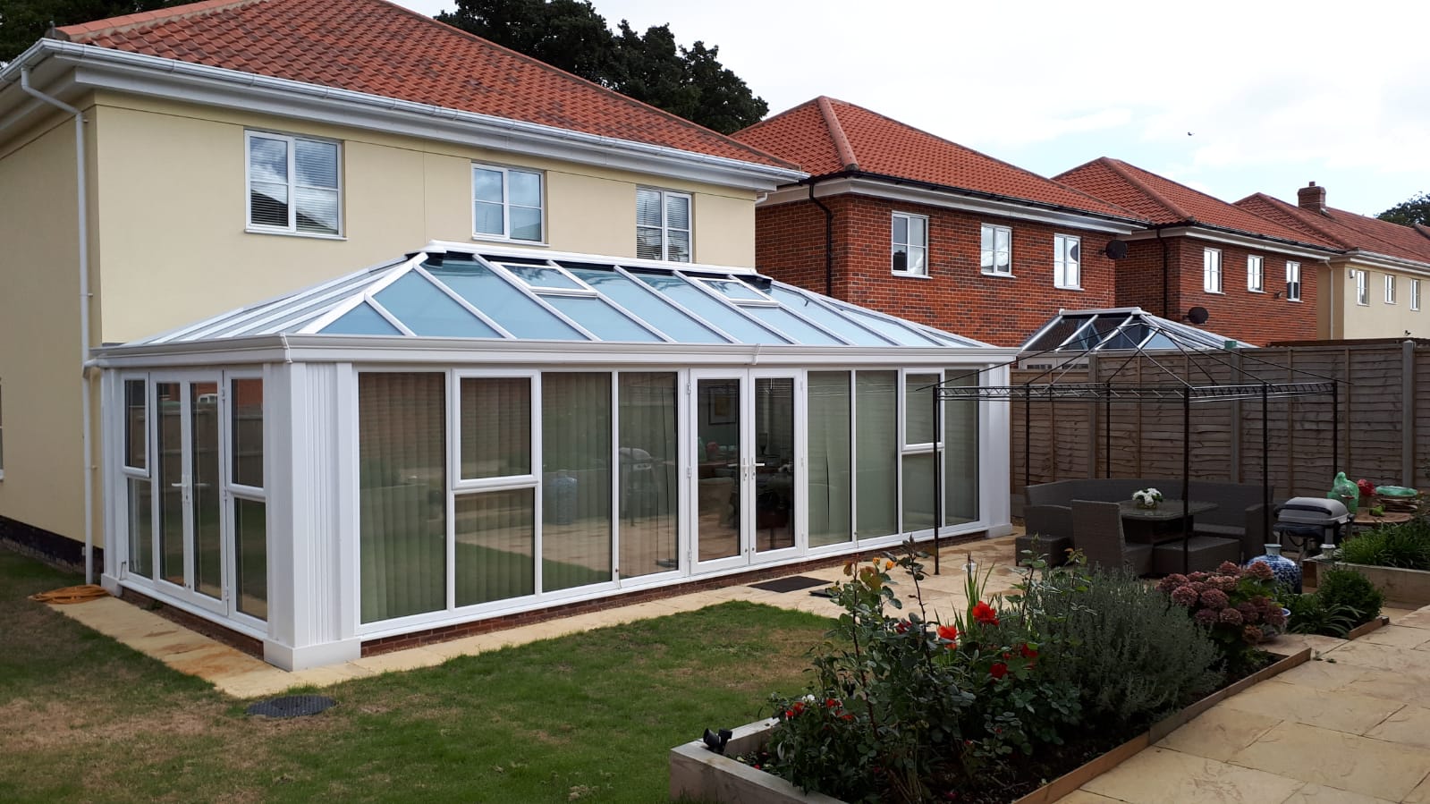 UPVC double-hipped Edwardian fully glazed conservatory with Loggia corner posts, glass roof with vents and cornice guttering – Bury St Edmunds, Suffolk
