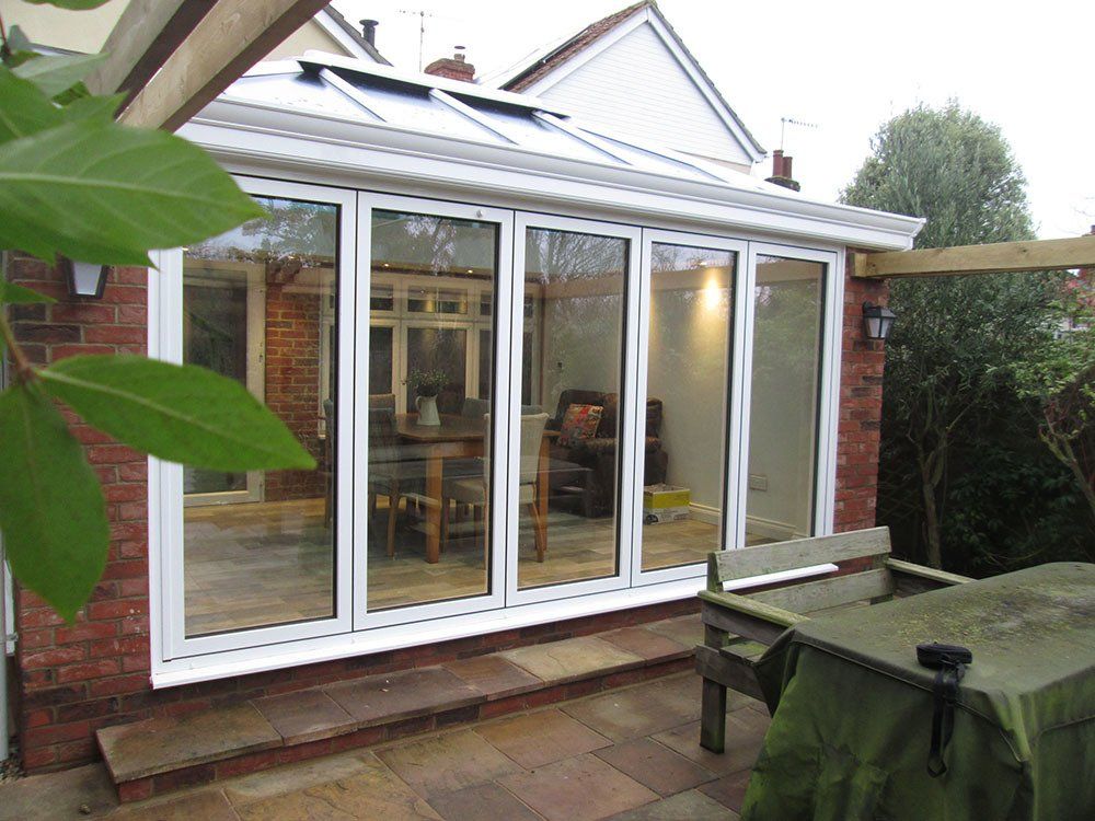 UPVC double-hipped Edwardian conservatory with brick pillars, Livin Room roof and aluminium bi-fold doors – Woodbridge, Suffolk