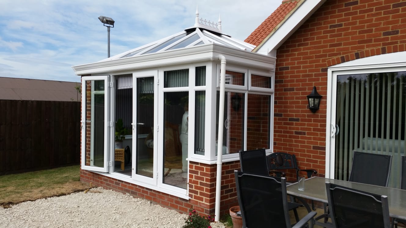 UPVC double-hipped Edwardian conservatory with brick pillars, Livin Room roof and aluminium bi-fold doors – Woodbridge, Suffolk