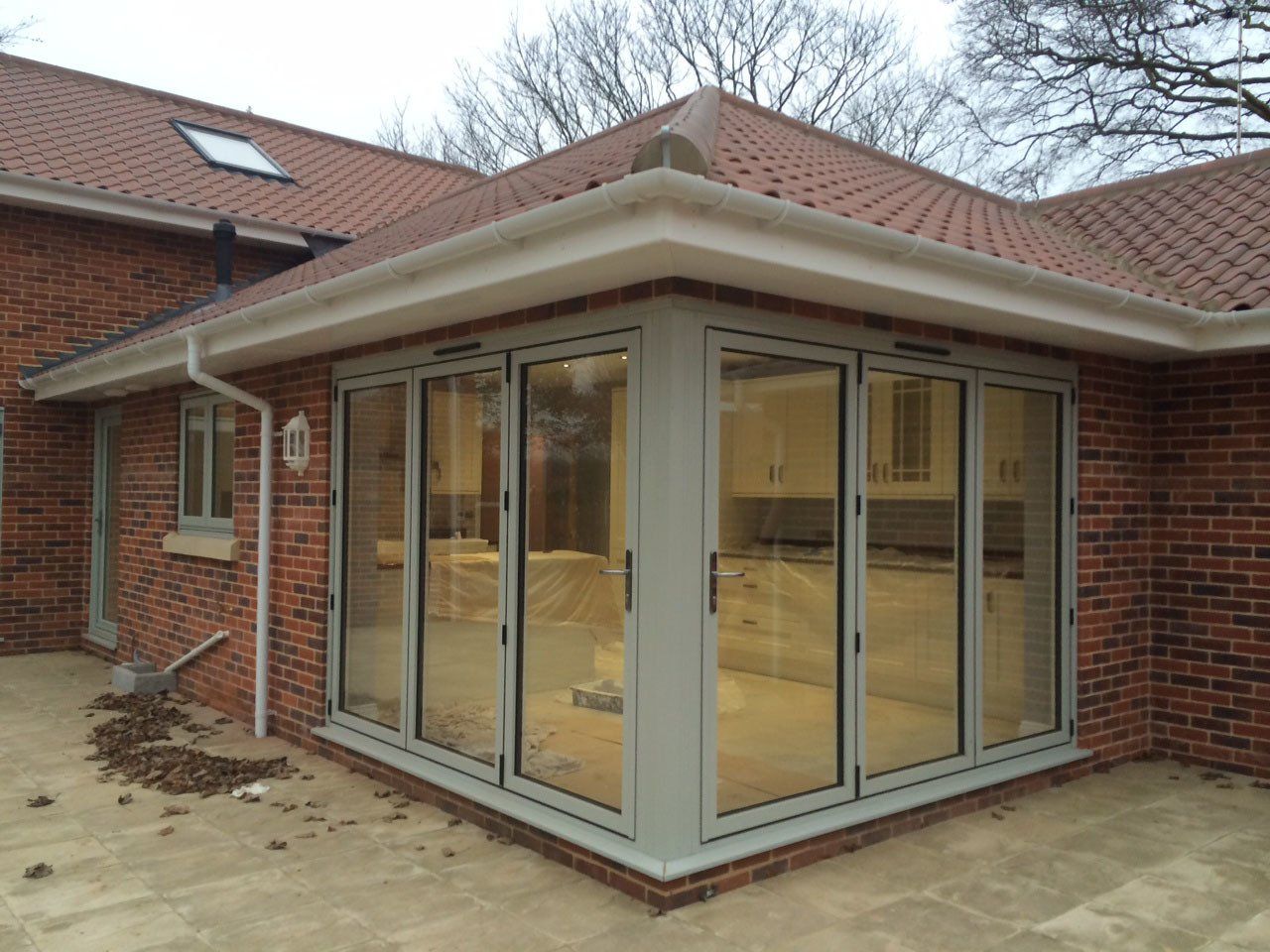 Aluminium bi-fold doors with corner post as part of new build, including Evolution Storm windows in French Grey – Beccles, Suffolk