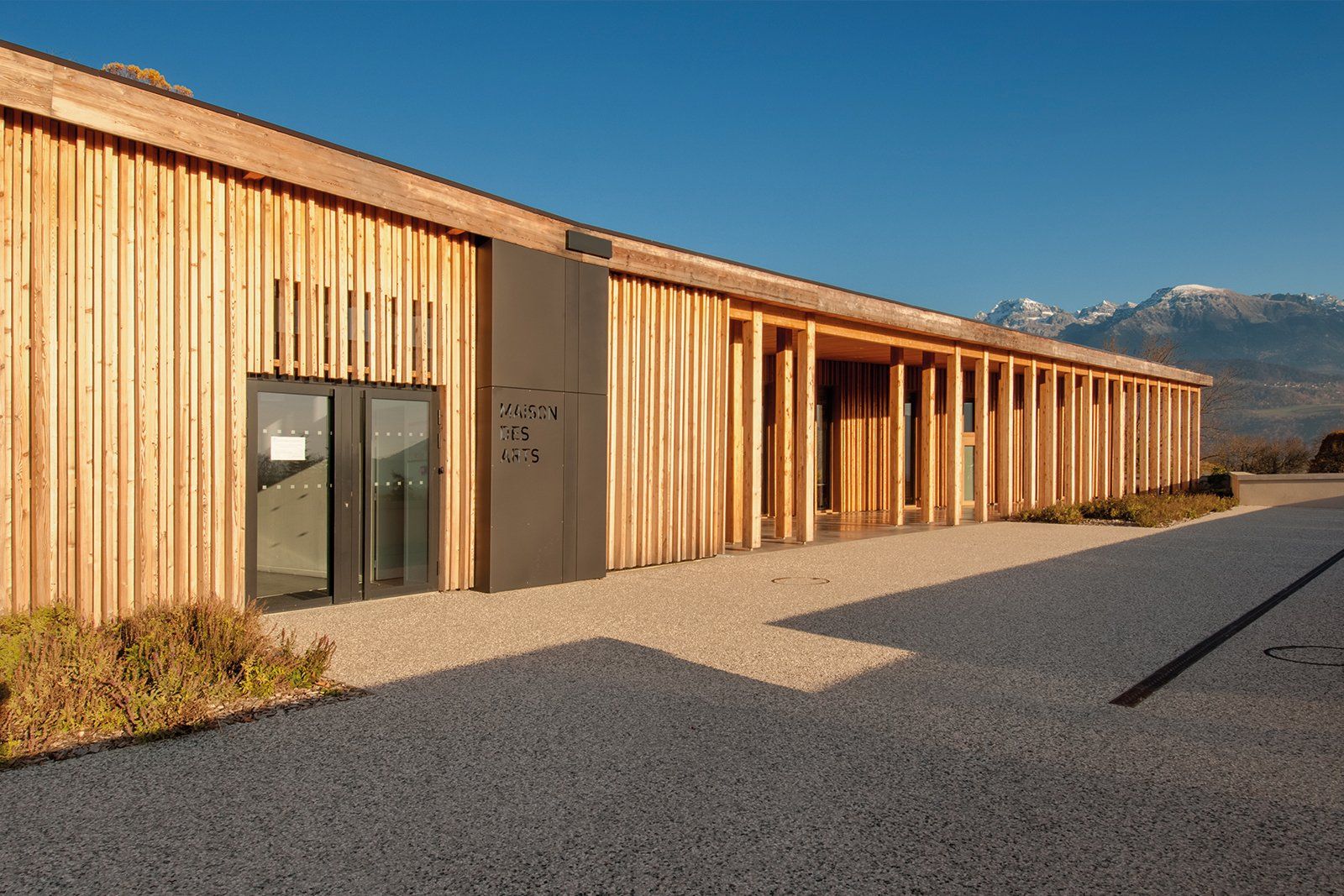 Un grand bâtiment en bois avec des montagnes en arrière-plan