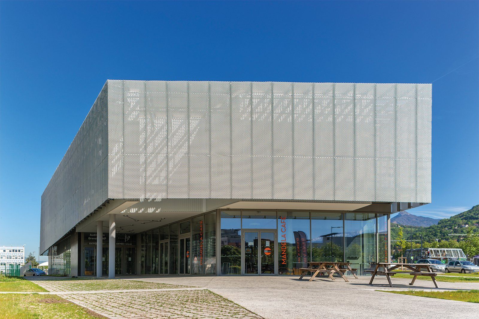 Un grand bâtiment avec beaucoup de fenêtres et un ciel bleu en arrière-plan.