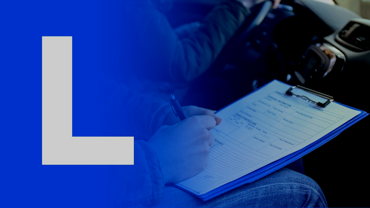 Een blauw L-bord is afgebeeld over een persoon die aantekeningen maakt in een auto; tijdens een rijexamen of rijles.