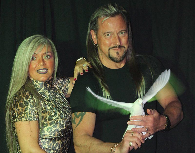 magician with a lady and bird