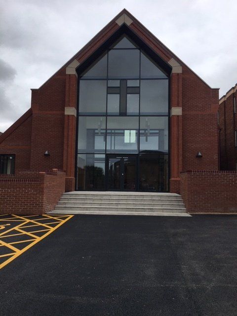 A large brick building with a cross in the window