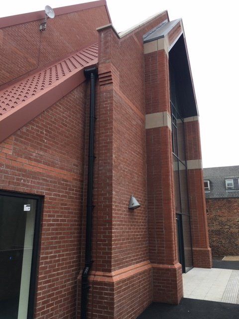 A large red brick building with a roof