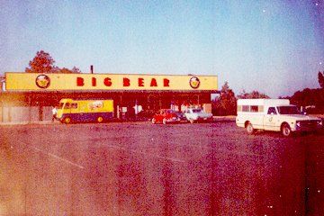 Big Bear grocery store exterior with cars in parking lot. Yellow and red signage, 1970s style.