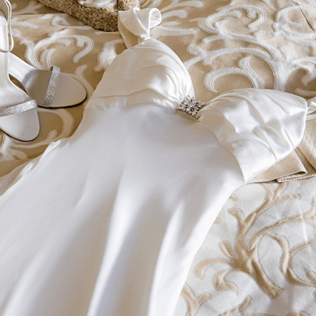 Wedding dress and shoes on bed