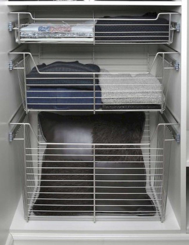 A closet filled with lots of clothes and pillows.