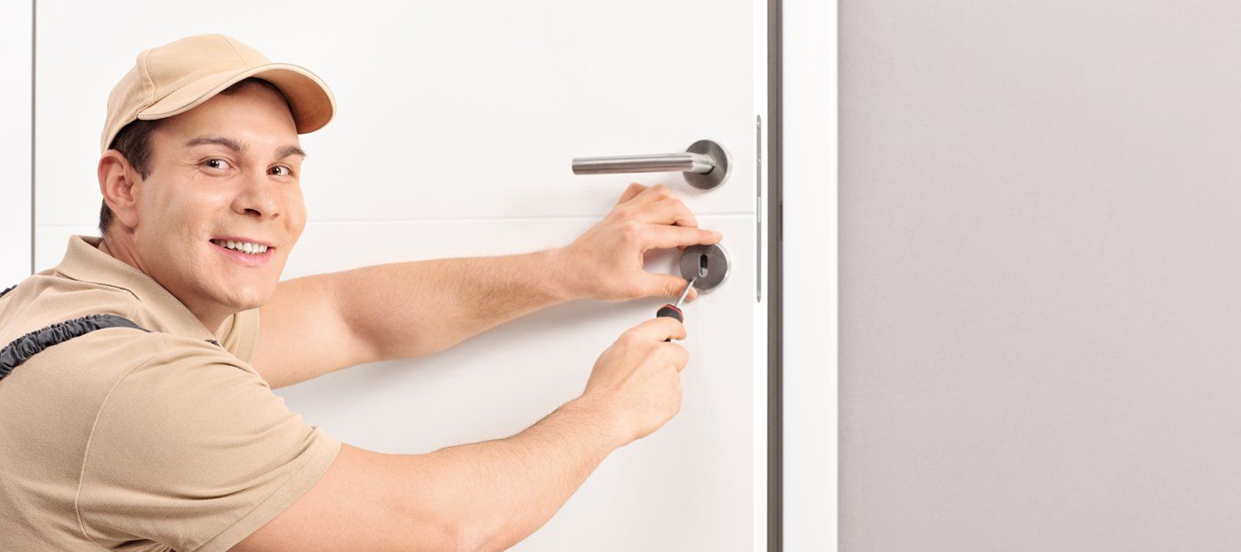 A man is fixing a door with a screwdriver.