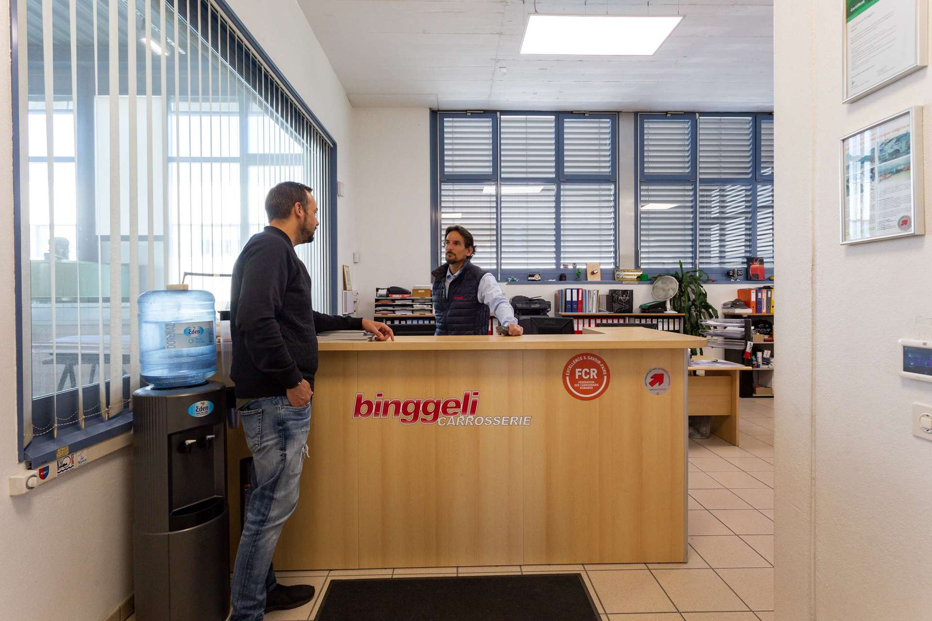 Deux personnes qui discutent à l'accueil de la carrosserie Binggeli